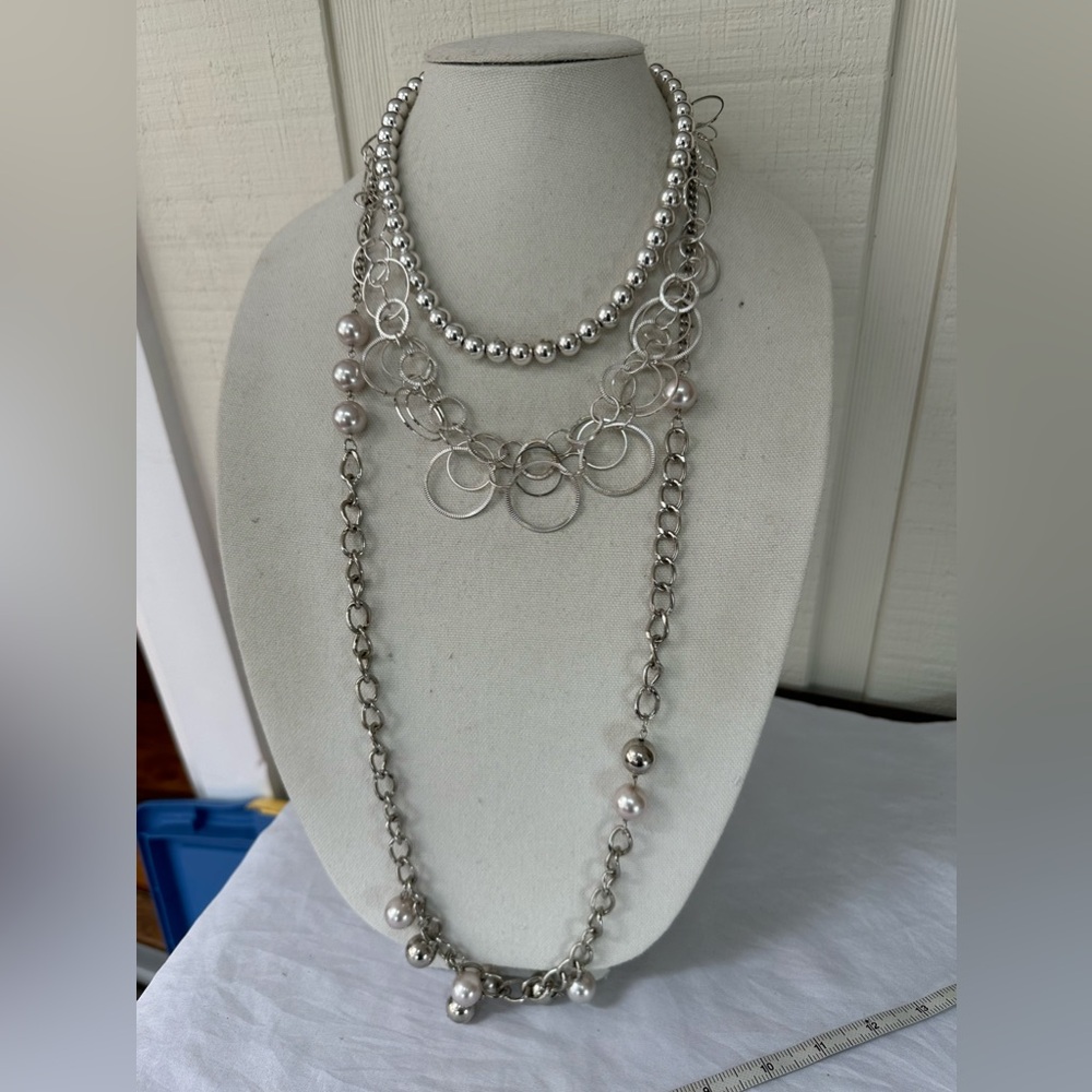 Three silvertone necklaces with dangles